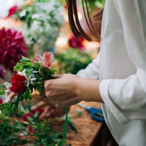 Fleuriste composant un bouquet dans l'atelier